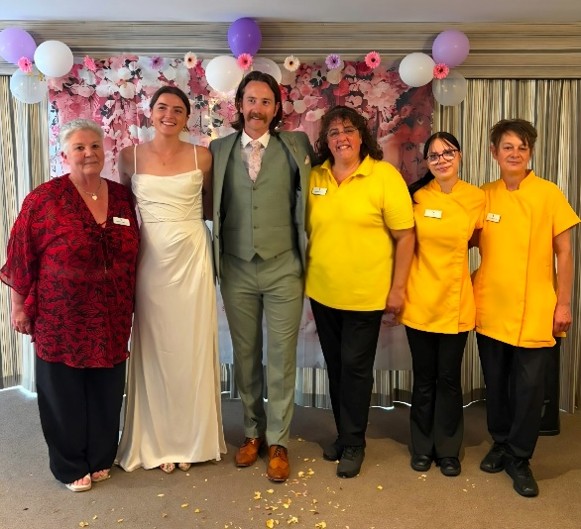 married couple standing with staff