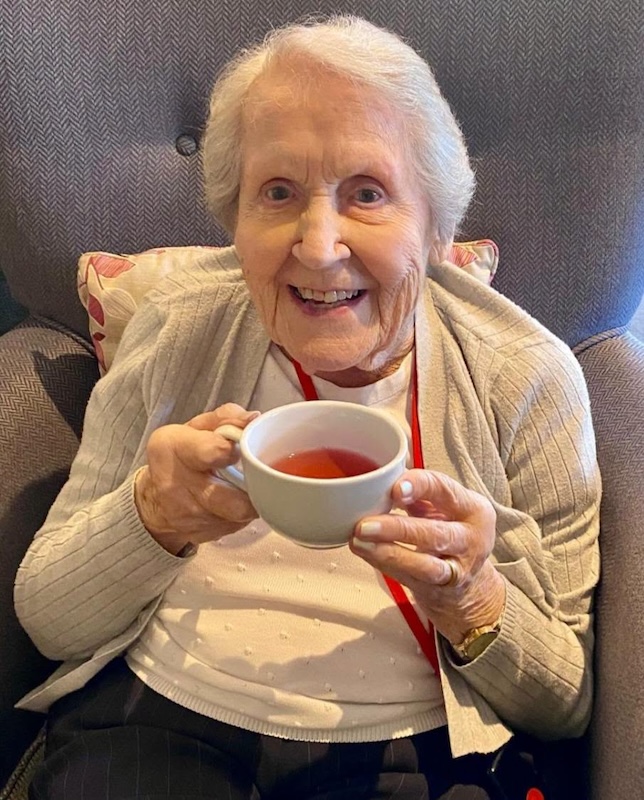care resident smiling with cup of tea