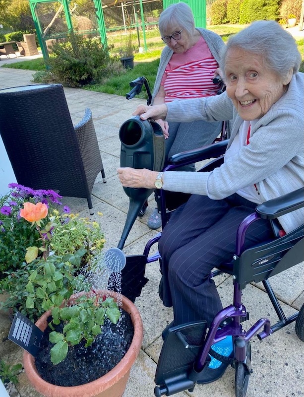 residents watering plants in garden